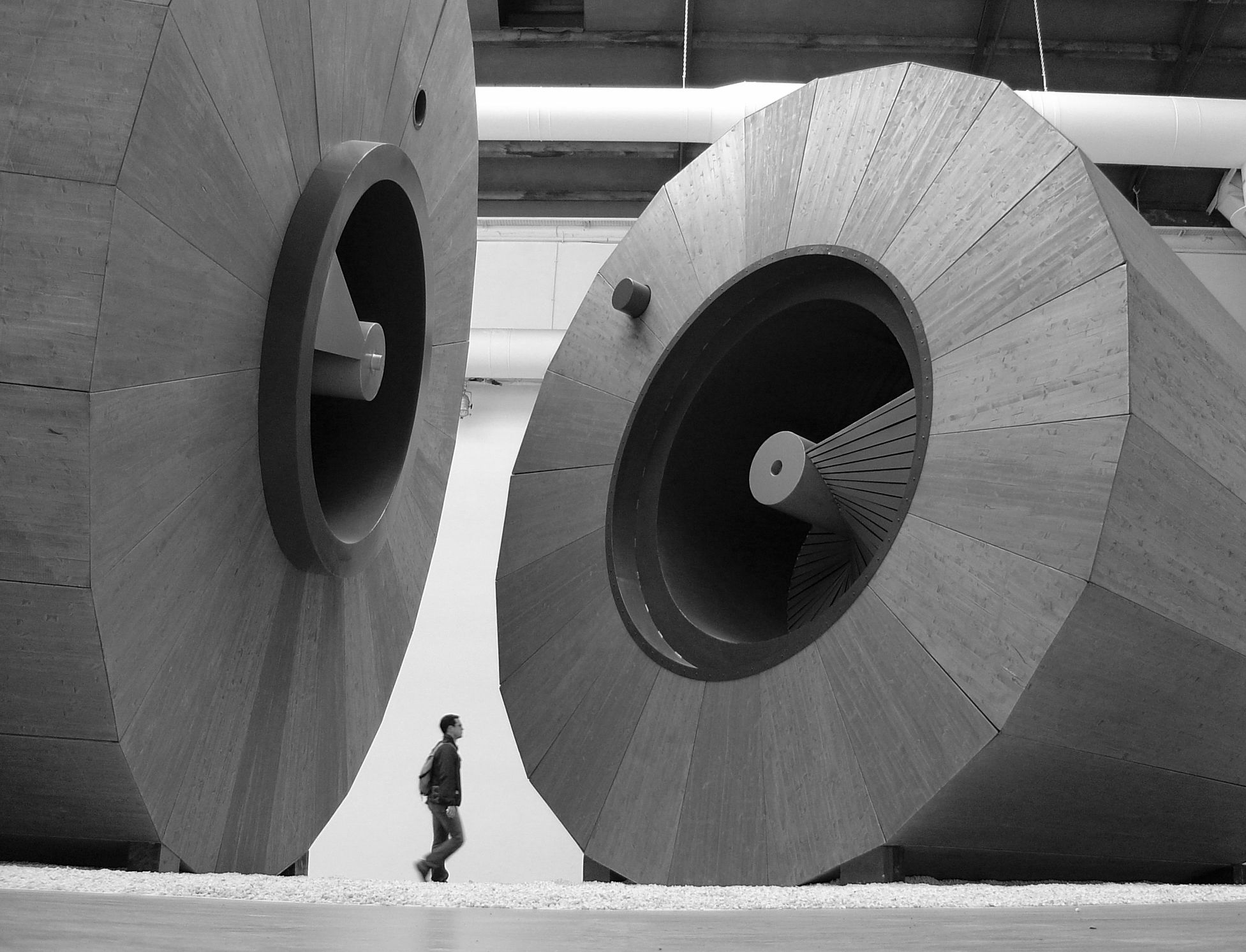 Giant wooden drums installation with a visitor walking between them