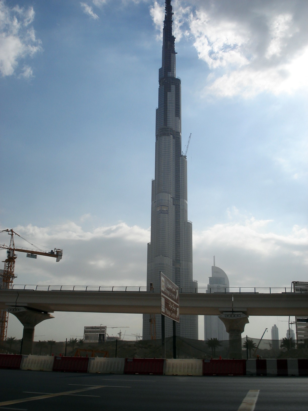 Burj Khalifa under construction behind a metro viaduct