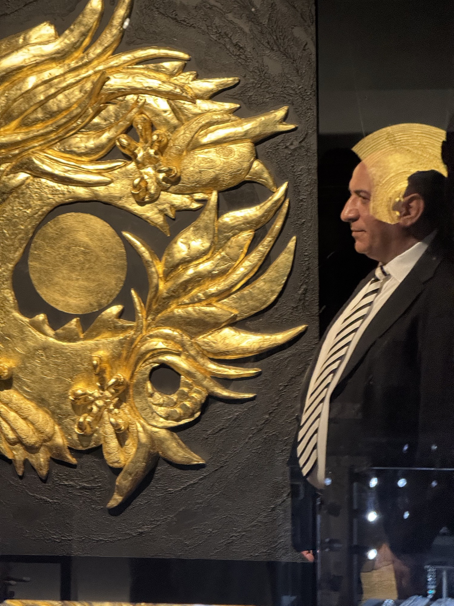 Gold-leaf relief painting with a guest in profile beside it