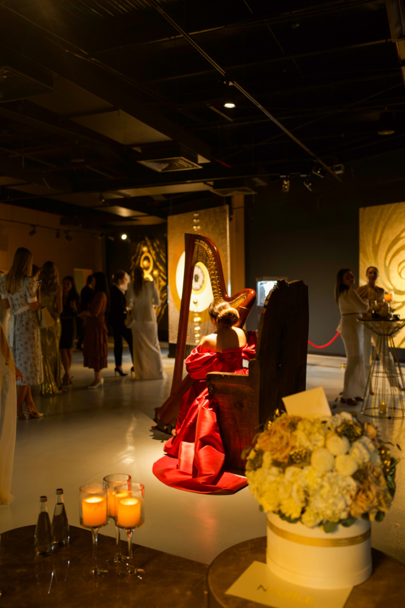 Harpist in a red dress playing in the gallery