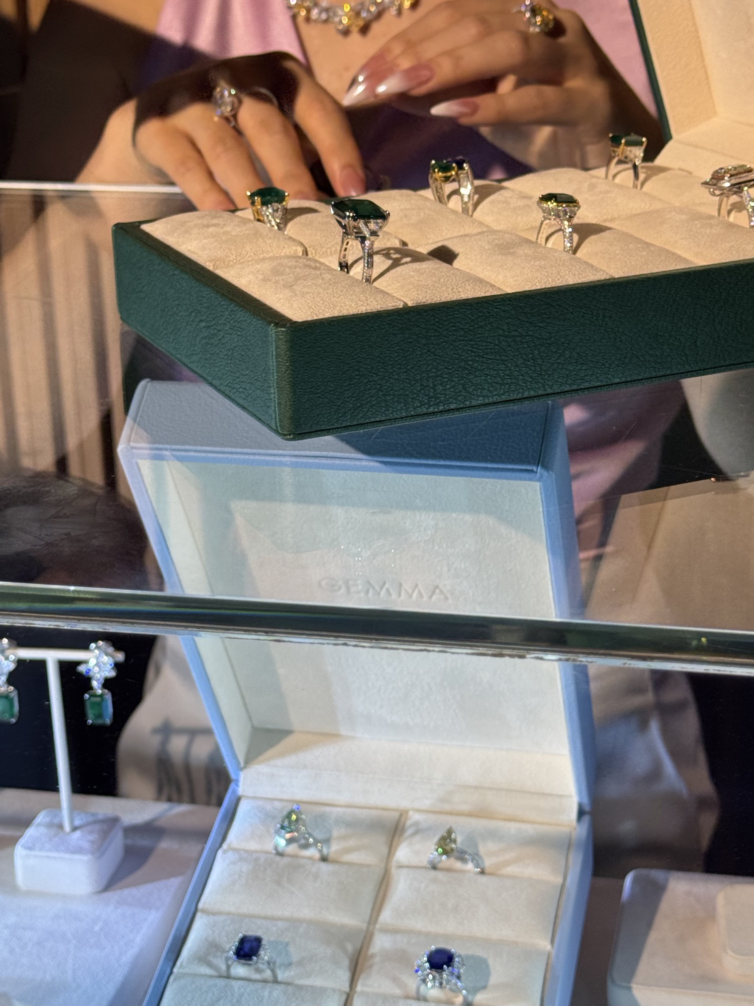 Trays of emerald and sapphire rings in a jewellery case