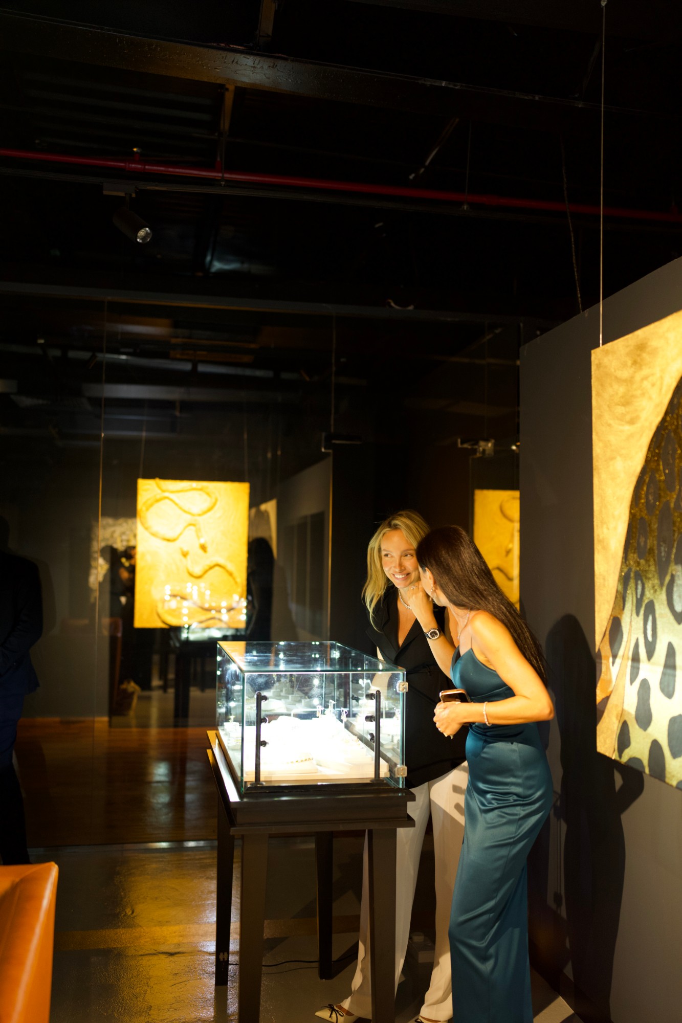 Two guests looking into an illuminated jewellery vitrine