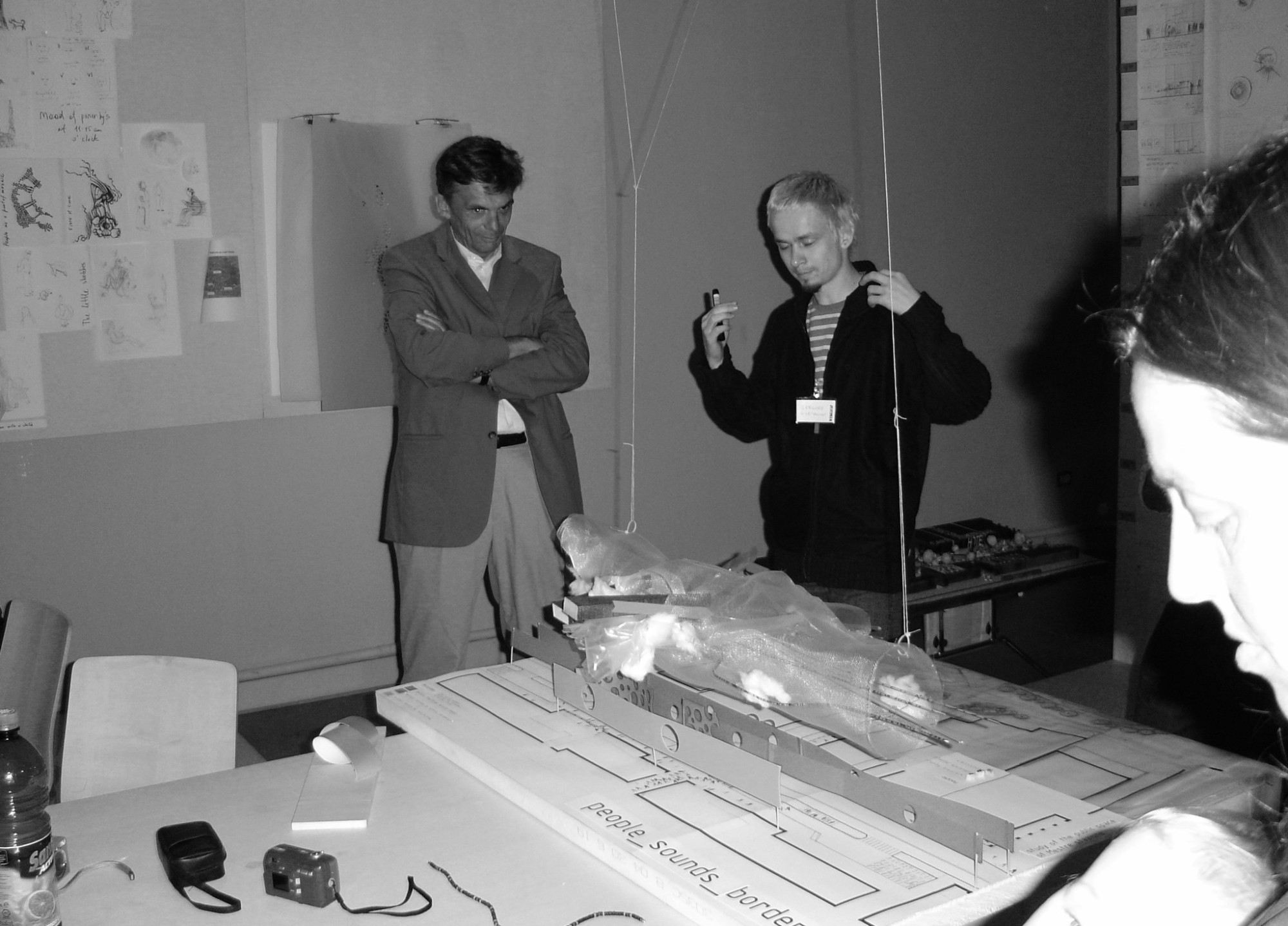 Workshop: two people discussing a model on a table