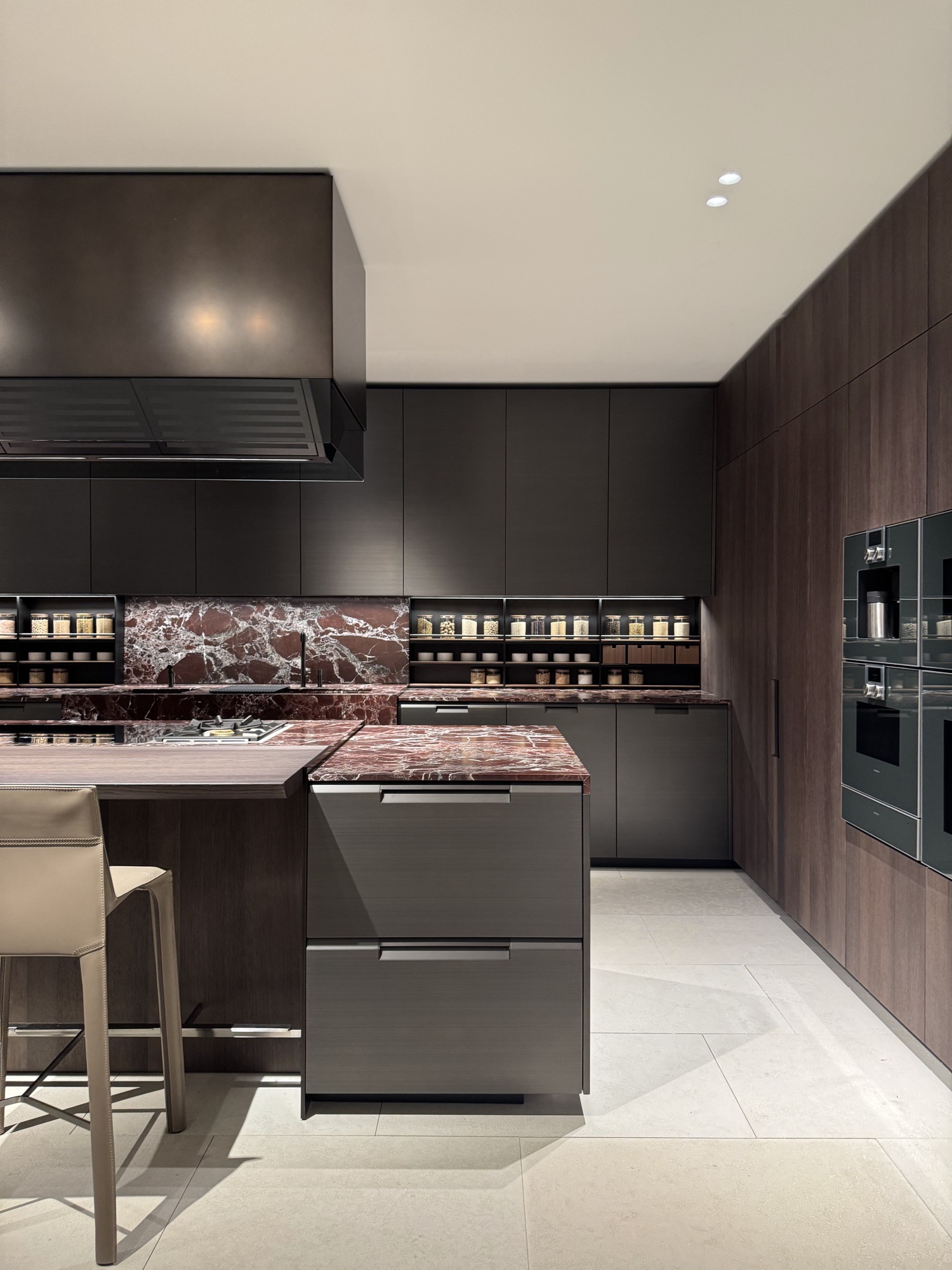 Dark kitchen with red marble worktop and integrated appliances