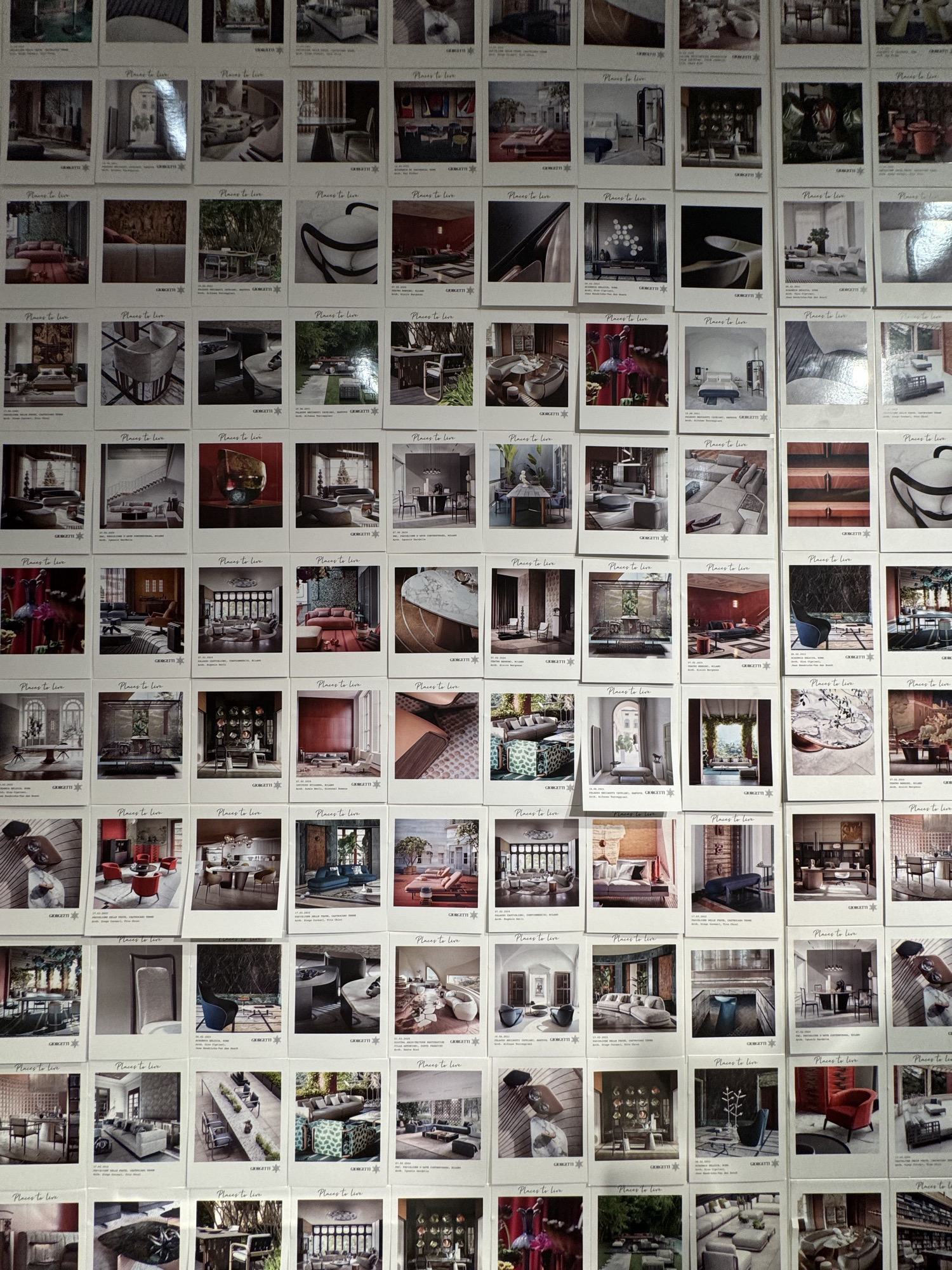 Wall covered with polaroid photographs of interiors