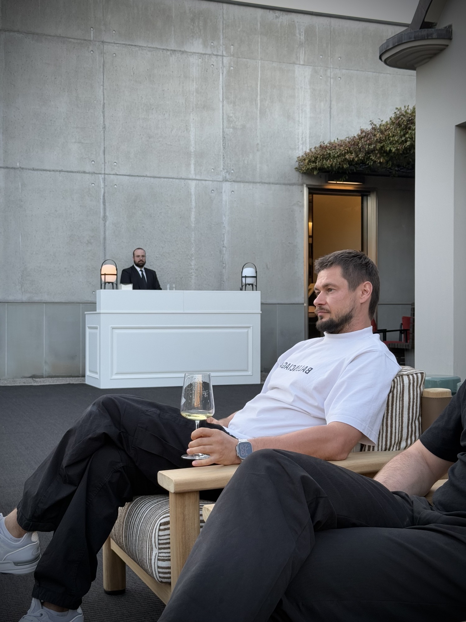 Roman Chertkov with a glass of wine on a terrace in the evening