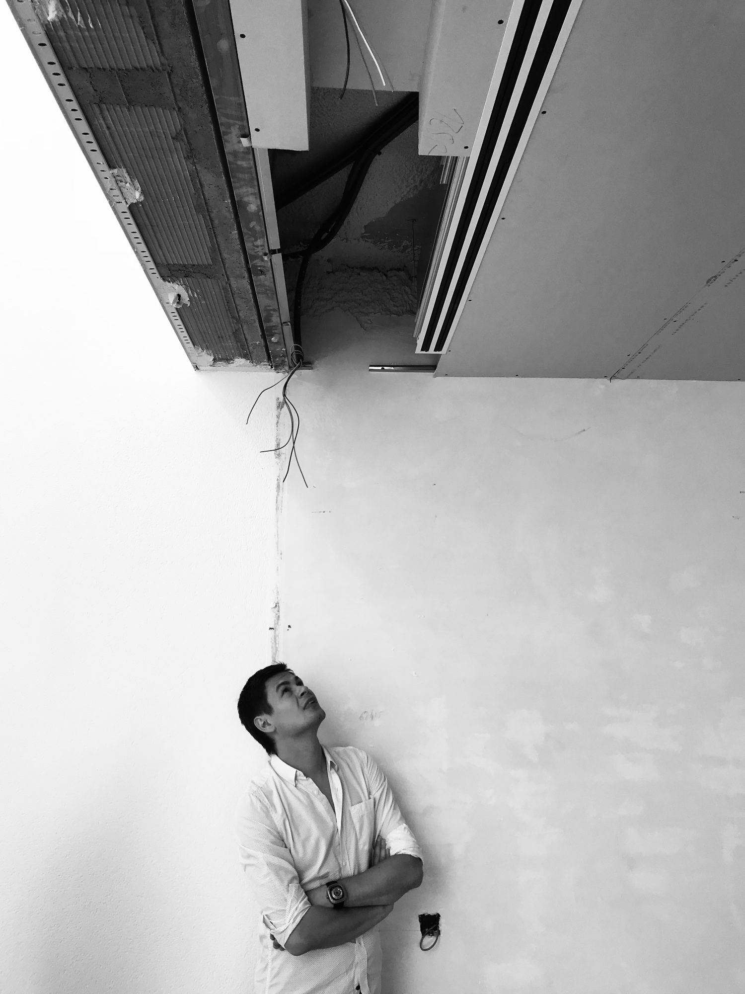 Roman Chertkov on site looking up at an unfinished ceiling