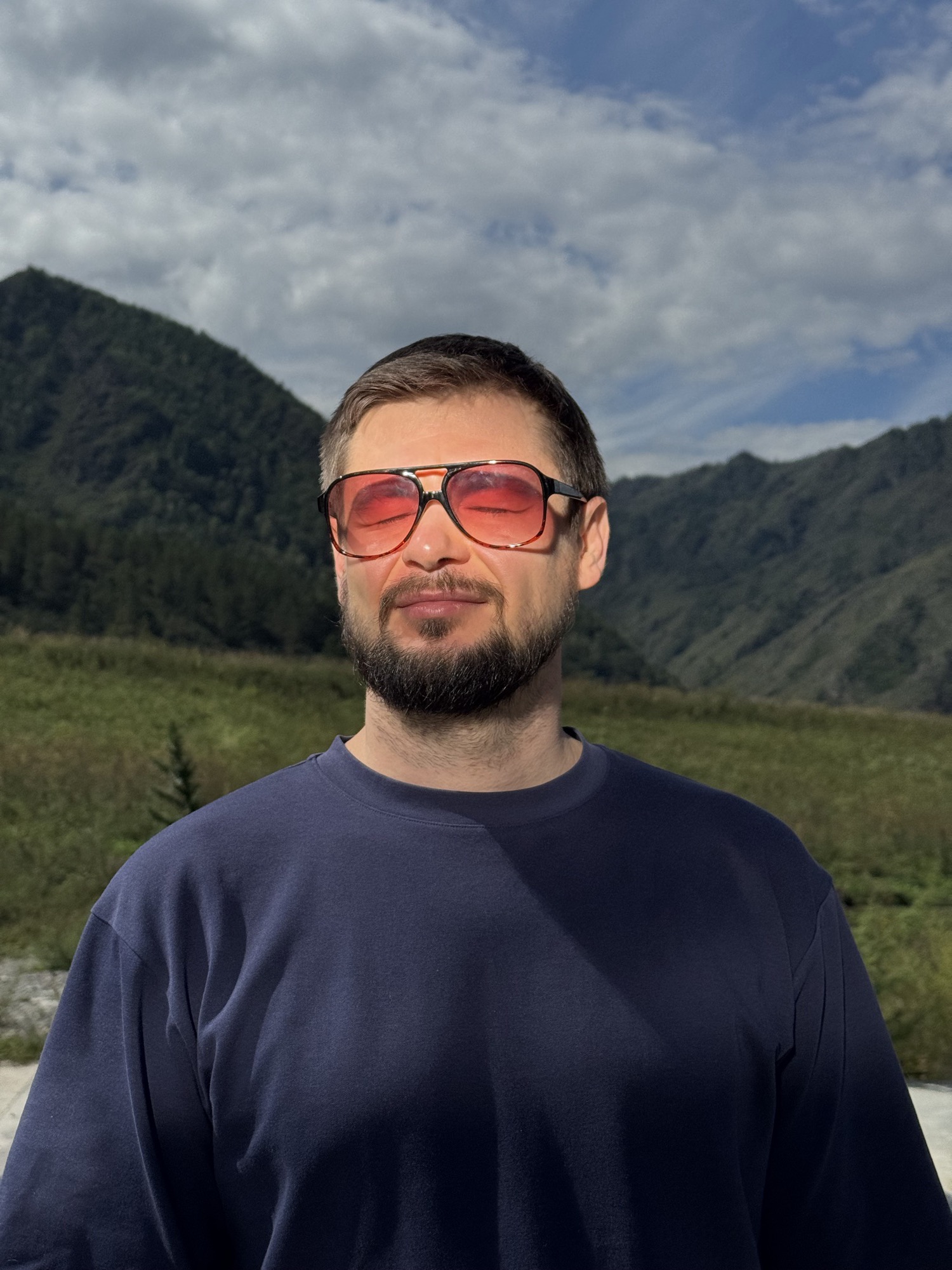 Roman Chertkov in sunglasses against a mountain landscape
