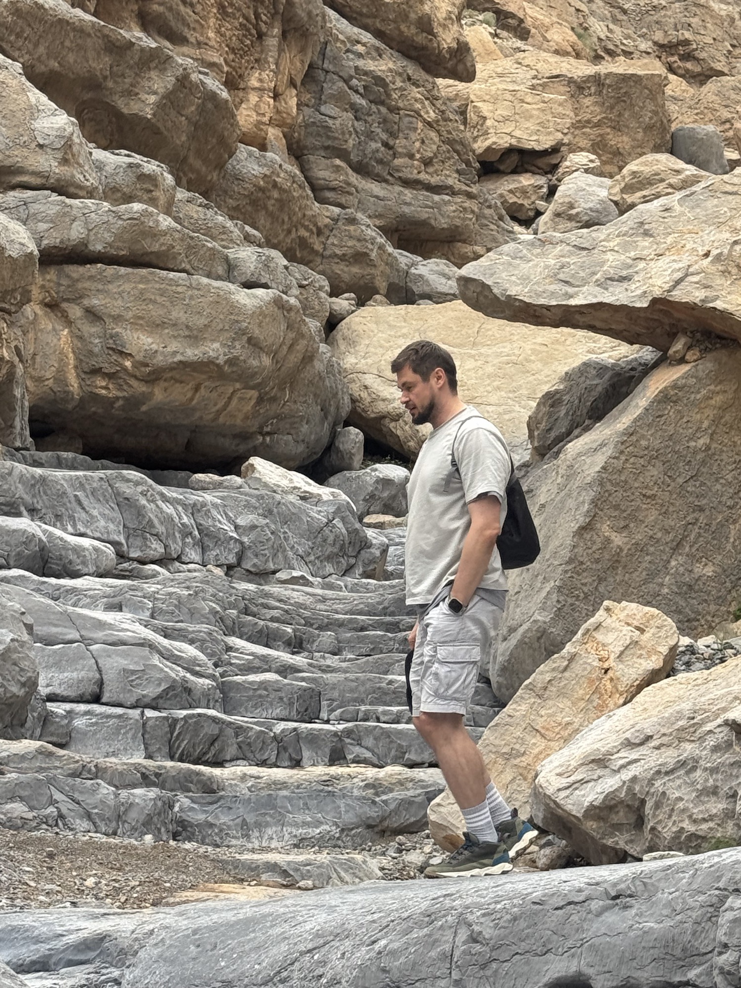 Roman Chertkov walking down rock steps in a narrow canyon